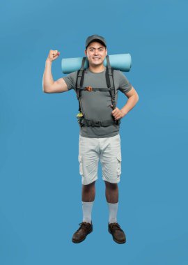 Gülümseyen erkek yürüyüşçü, mavi bir zemine dayanan esnek koluyla gücünü sergiliyor.