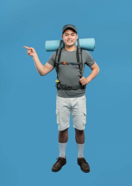 Sırt çantalı, şortlu ve kapaklı bir adamın tam pozu.