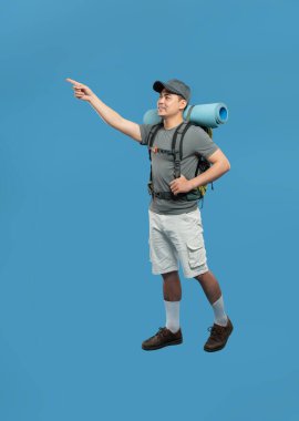 Yürüyüşçü, mavi arka plan macera ve keşiflerine karşı yolculuk için gerekli teçhizatı ile yönü gösterir