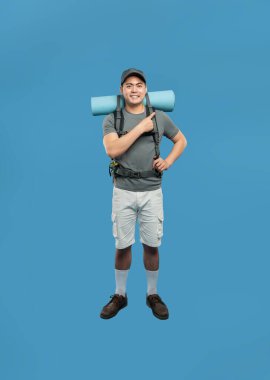 Yürüyüş kıyafetleri ile gülümseyen bir adam yan tarafı gösterir.