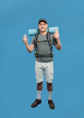 Gri tişörtlü bir yürüyüşçünün tam boy portresi sırt çantası savar tamam, keşfetmeye hazır.