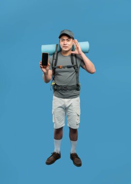 Yürüyüşçünün gri gömleği var. Şortu beyaz, ayakkabısı kahverengi. Paketi var.