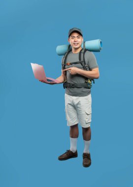 Mavi zemin üzerinde dizüstü bilgisayarı işaret eden bir gezgin teknolojik modern gezginlerle maceraya hazır.