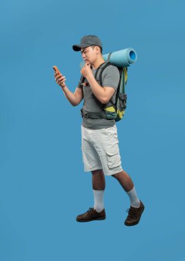 Yürüyüşçünün telefonuna bakarken tam görüntüsü. Gördüğü bilgiden emin değilmiş gibi görünüyor.