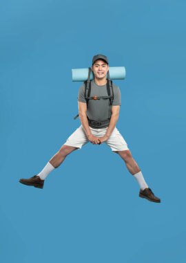 Sırt çantasıyla neşeli bir yürüyüşçü mavi bir ortama karşı, eğlence ve macerayı sembolize ediyor.