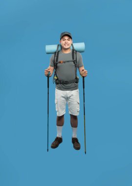 Sırtında sırık ve sırıkla gülümseyen bir yürüyüşçü mavi bir maceraya hazırdır.