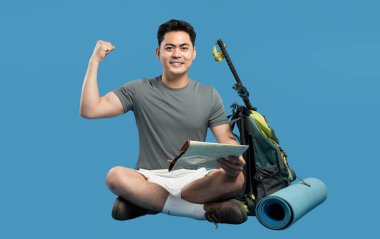 Haritalı tutkulu yürüyüşçü, sırt çantası direkleri ve mavi arka planda kamp kurarak macerayı kutluyor