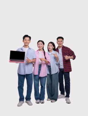 Dört kişilik bir ekip gururla bir dizüstü bilgisayar sergiliyor. Her üye ona gülümsüyor.