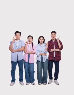 Dört gülümseyen genç yetişkin, heyecan ve birlik içinde yukarıyı işaret ediyor. Düz beyaz bir arka plandalar.