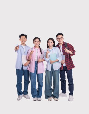 Gülümseyen üniversite öğrencilerinden oluşan çeşitli bir grup ellerinde not defterleri, gençlik güvenini göstererek poz veriyor.