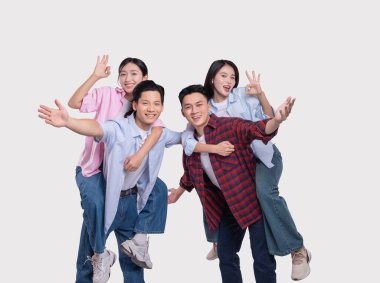 İki genç adam iki genç kadını sırtında taşıyor Herkes gülümsüyor ve güzel jestler yapıyor