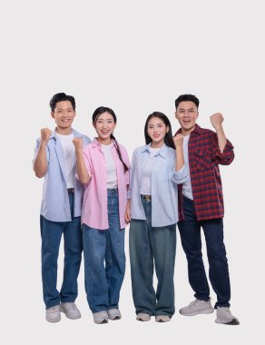 Dört gülümseyen genç yetişkin bir arada durur ve bir neşe ve başarı jesti olarak yumruklarını kaldırırlar.