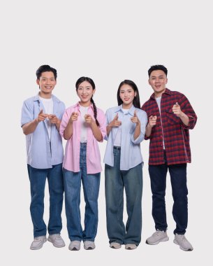 Gülümseyen dört kişiden oluşan çeşitli bir grup öne doğru işaret ediyor. Parlak ifadeli günlük kıyafetler giyiyorlar.