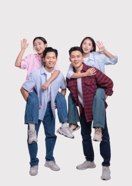 İki gülümseyen adam iki kadını sırtında taşıyor. Hepsi mutlu ve tasasız görünüyorlar.