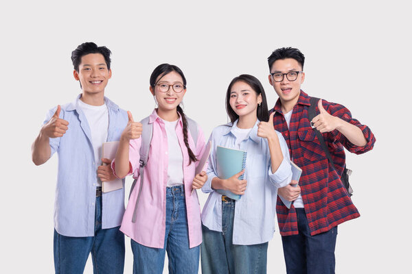 Группа молодых людей, подающих большие пальцы и держащих блокноты, предполагают, что они оптимистичные студенты.