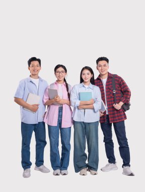 Dört öğrenciden oluşan bir grup, kitaplarını sınıfa giderken poz verip gülümsüyor.