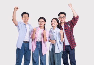 Gülümseyen dört yetişkin öğrenciden oluşan çeşitli bir grup havada yumruklarla kutluyor.