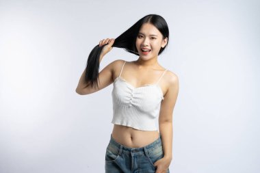 Hevesli genç kadın uzun dalgalı saçlarını temiz beyaz bir arkaplana yaslıyor.