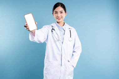Laboratuvar önlüklü gülümseyen bir doktor elinde mavi bir fona karşı boş ekranlı bir akıllı telefon tutuyor.