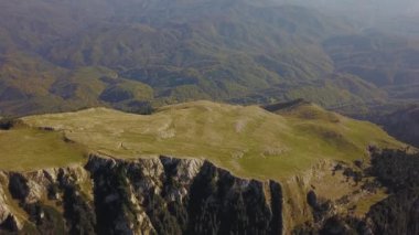 Dağlardaki yüksek irtifa platosunun üzerinde uçuyorlar. Keskin uçurumlar ve vadiler vahşi kozalaklı ormanlarla çevrilidir. Sonbahar sezonu. Carpathia, Romanya.