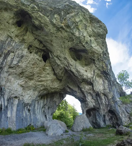 Vahşi kayın ormanlarının içindeki dağlık bir bölgede bulunan doğal, aşınmış bir oyun salonu. Kayalık mağaranın altında büyük kayalar var. Carpathia, Romanya.