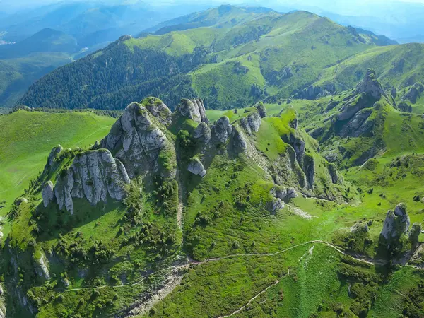 Ciucas Dağları 'nın insansız hava aracı panoraması. Alp otlaklarında aşınmış kireçlenmiş kaya yığınları çarpıcı taş yığınları oluşturuyor. Gökyüzü açık, mavi ufuk. Karpatlar, Romanya. 