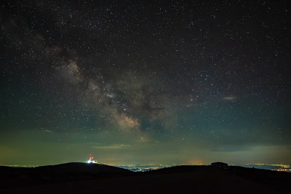 Samanyolu 'nun çekirdeği dağlardan görülüyor. Bir yaz gecesinde radyo, gsm kulesi ve şehir kirliliğinden yükseliyor. Ufuk turuncu renkte yanar.. 