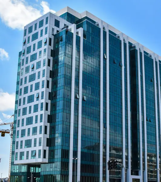 Bu fotoğraf, cam ve betondan oluşan zarif kombinasyonuyla karakterize edilen Belgrad Rıhtım Projesi 'nden yeni inşa edilmiş bir binayı gösteriyor. Bina çerçeveye hükmediyor, yukarıdaki gökyüzü ise yüksek mavi bir yansıma yapıyor.