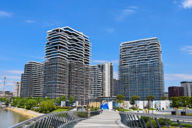 Belgrad Rıhtım Binaları yapım aşamasında, Sava Nehri çevresi yeşilliklerle dolu ve güneşli bir günde yürüyen insanlar, 20 Mayıs 2025