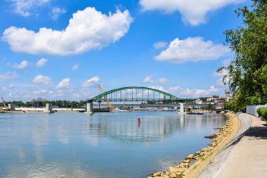 İşçiler ve makineler Belgrad 'daki Eski Sava Köprüsü' nü kaldırırken, arka planda Kalemegdan ve Yeni Belgrad silueti yer alıyor.