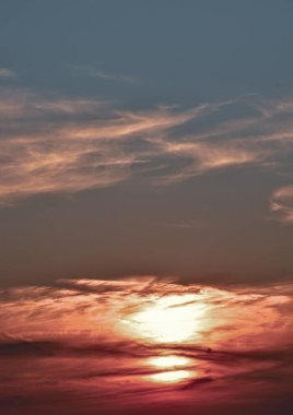 Gün batımının sakin manzarası. Bulutlar büyülü tonlarla aydınlanıyor. Arka plan, doğa temaları ve huzur dolu sahneler için mükemmel..