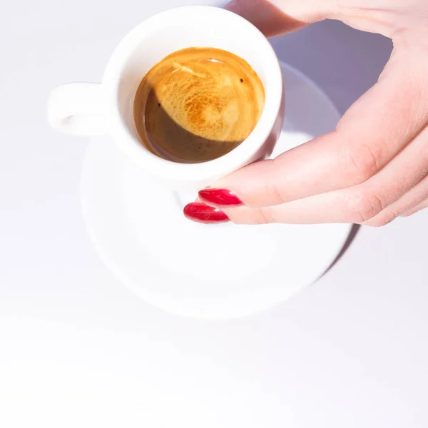 The girl raises a cup of coffee and toasts to life. Rest and enjoyment. Conceptual setting and minimalism.