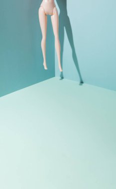 Naked and bare feet levitation and floating in a blue room. Conceptual set.