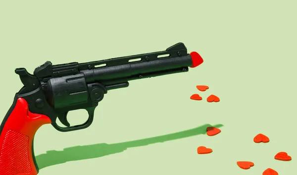 Yere Dağılmış Bir Silah Kırmızı Kalpler Pastel Yeşili Arka Plan — Stok fotoğraf