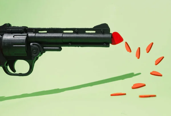 Yere Dağılmış Bir Silah Kırmızı Kalpler Pastel Yeşili Arka Plan — Stok fotoğraf