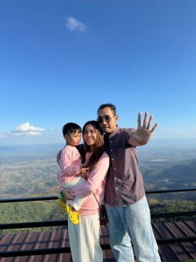 Mutlu küçük bir çocuk bir pencerede oturur, neşeyle gülümser.