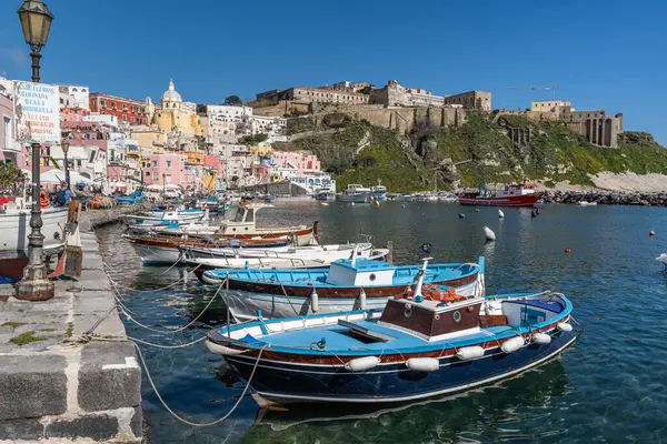 Procida 'daki Corricella limanına demirlemiş balık ağları ve renkli balıkçı tekneleri. Procida, Campania, İtalya, Mart 2023