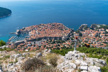 A cable car steadily climbs a hill, transporting passengers while the city of Dubrovnik provides a stunning backdrop, Croatia