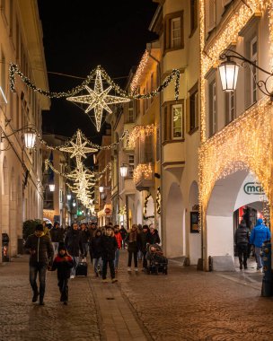Merano, Alto-Adige, İtalya, Aralık 2023. Merano 'da canlı bir sokakta canlı bir gece sahnesi. Parlayan Noel ışıklarıyla süslenmiş.