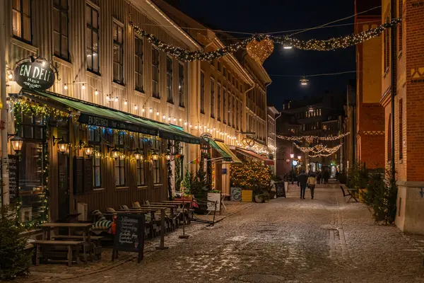 Göteborg, İsveç, Ocak 5, 2024. Haga Mahallesi 'nin dar bir caddesinde şenlikli çelenklerle süslenmiş büyüleyici dükkanlar var.