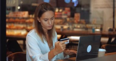 Kredi kartı tutan birden fazla iş kadını dizüstü bilgisayar kullanıyor ve kolay ödemeler yapıyor. E-bankacılık uygulama servisi
