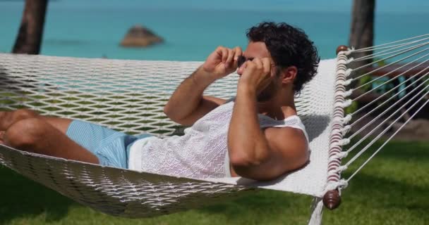 피부가 햇볕에 그을리고 선글라스를 해먹에 뜨거운 여름날 일광욕을 — 비디오