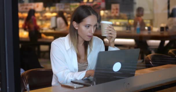 Νεαρή Πολυεθνική Όμορφη Γυναίκα Πίνει Καφέ Δουλεύει Φορητό Υπολογιστή Ελεύθερη — Αρχείο Βίντεο