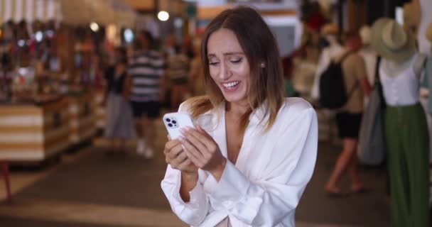 Szczęśliwa Radosna Młoda Wielonarodowa Kobieta Pozytywnymi Emocjami Sprawdzająca Zawartość Smartfona — Wideo stockowe