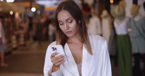 Εκπληκτική Γυναίκα Αυτοπεποίθηση Που Χρησιμοποιεί Smartphone Στο Κατάστημα Ρούχων Ελέγχοντας — Αρχείο Βίντεο