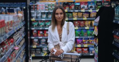 Mutlu bir kadının portresi, müşteri, tüketici, kameraya bakan, yiyecek pazarında alışveriş arabasıyla poz veren