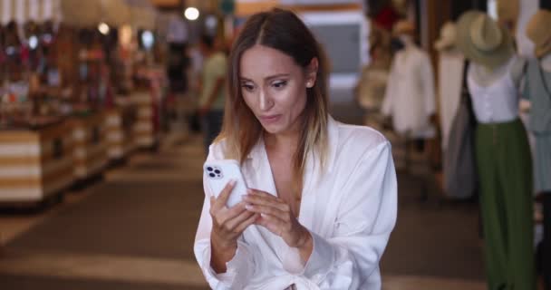 Όμορφη Μελαχρινή Γυναίκα Shopaholic Χρησιμοποιώντας Smartphone Χαίρεται Για Τις Εκπτώσεις — Αρχείο Βίντεο