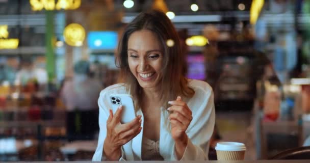 Šťastná Běloška Usmívá Veselým Zubatým Úsměvem Sedí Kavárně Čte Dobré — Stock video