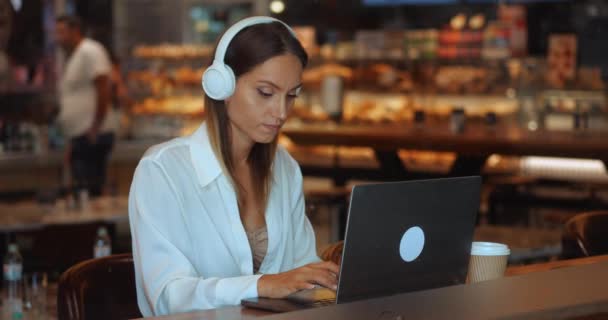 マルチタスクビジネス女性 起業家 ノートパソコンでのヘッドセット通信のコピーライターテキストの入力新しいプロジェクトの計画 — ストック動画