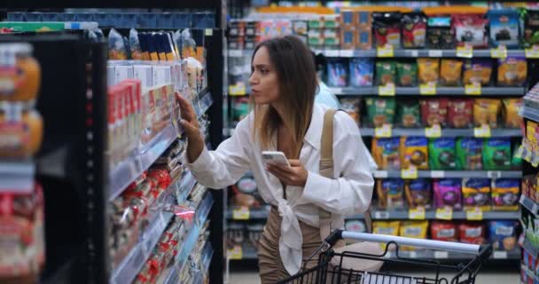 Fiatal Fogyasztó Okostelefon Használatával Szupermarketek Polcain Lévő Termékekkel Kapcsolatos Információk — Stock videók